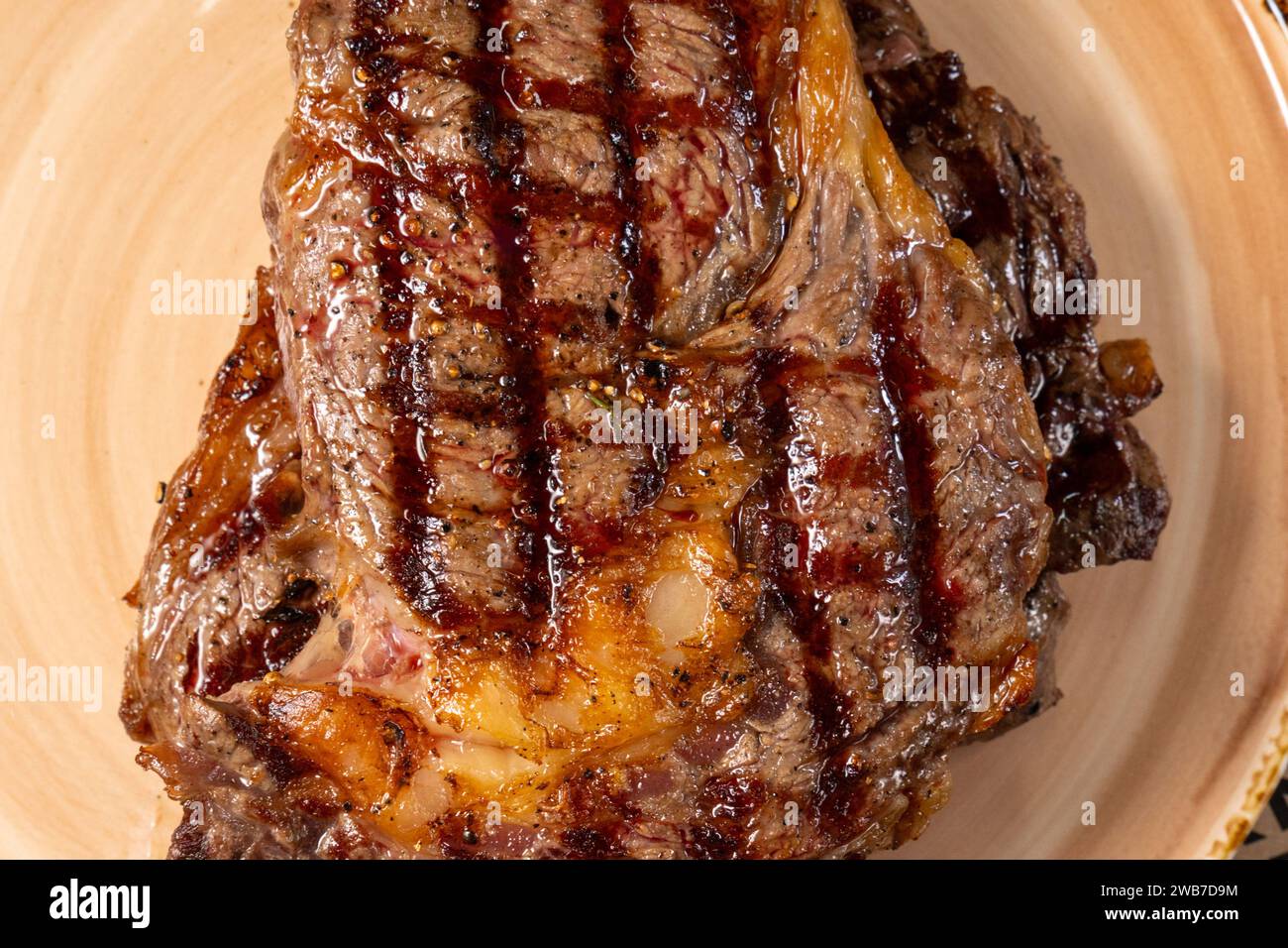Grilled steak presented on plate, highlighting the rich caramelization and irresistible char marks. Stock Photo
