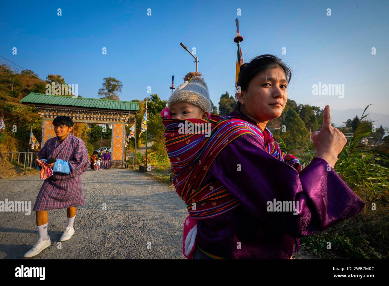 A Bhutanese woman carrying her child on her back shows the voting mark