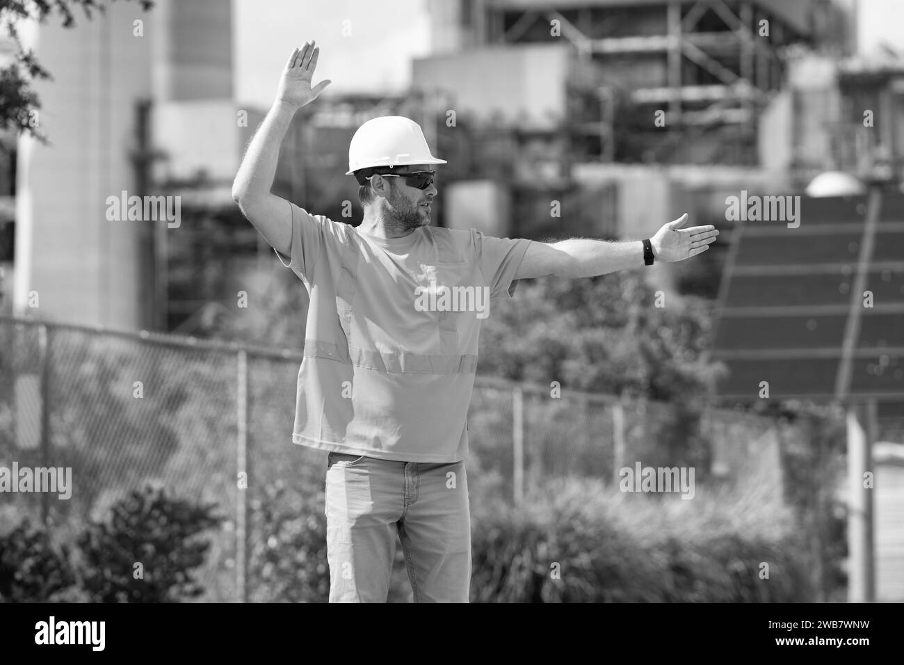 Construction worker at work. Man wearing hardhat and safety vest at construction site Stock Photo