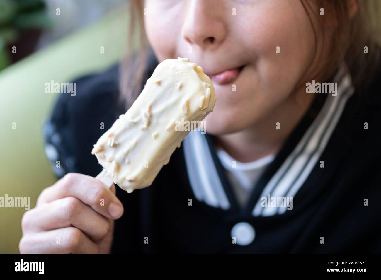 Little asian girl open widen mouth eating ice cream Stock Photo