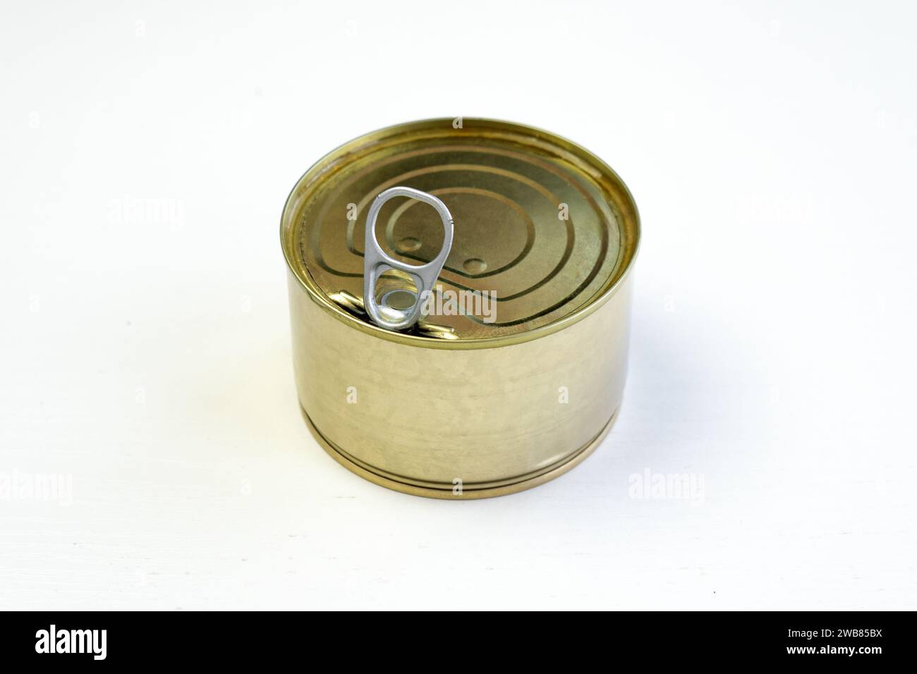 Unlabeled canned tuna on white background. A blank mockup tin-coated steel tuna can with open lid on white table. Canned fish steak and preserved food Stock Photo