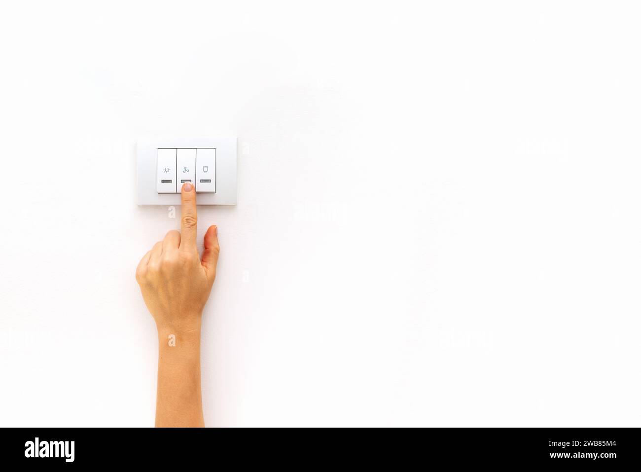 Switch on and switch off light. Control of electricity consumption at home banner. Female finger on light switch. Stock Photo