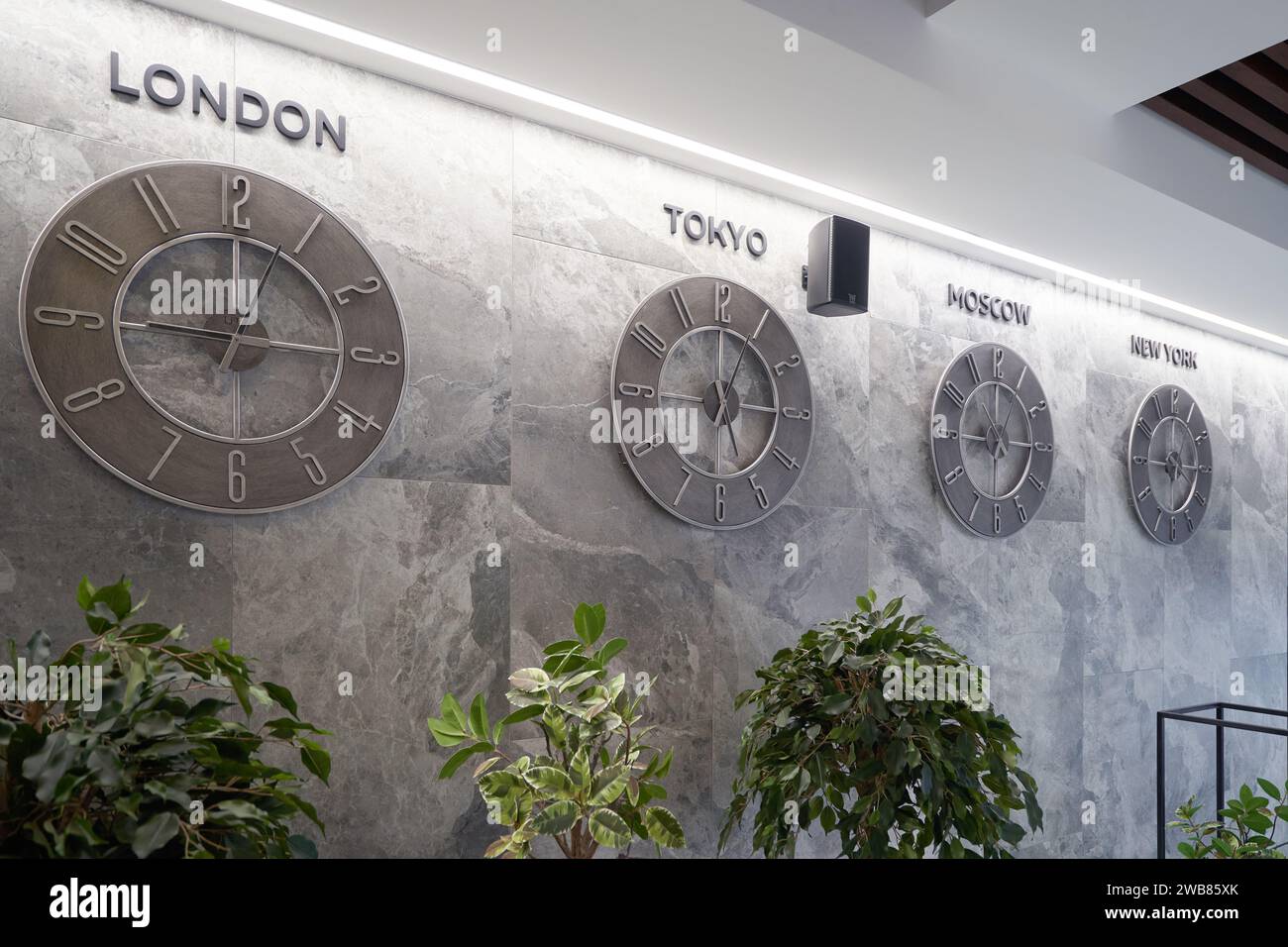 Wall clock with cities on the hotel wall Stock Photo