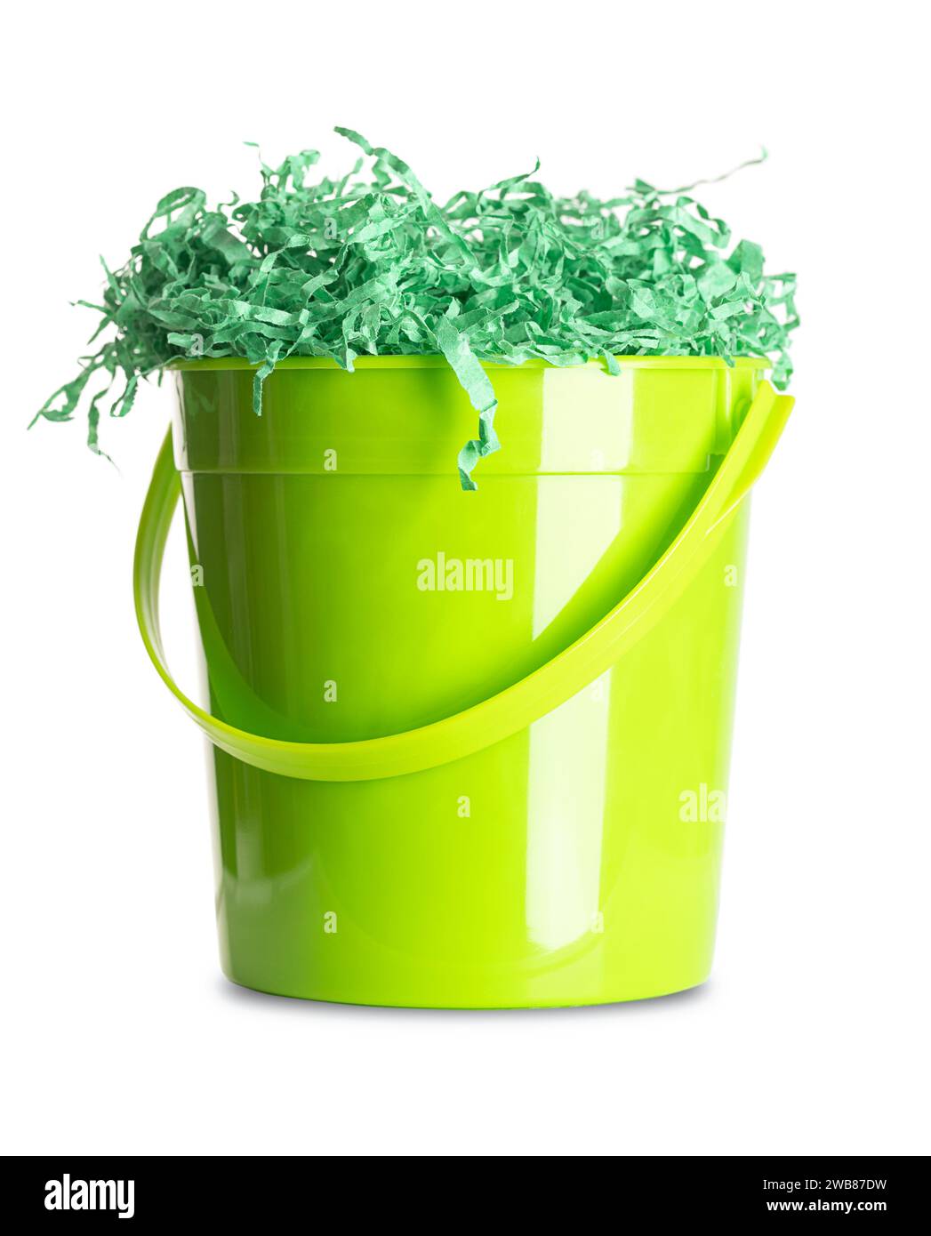 Paper Easter grass in a green plastic bucket. Vibrant colored and crinkled gift basket shred for filling and decoration, stuffed into the bucket. Stock Photo