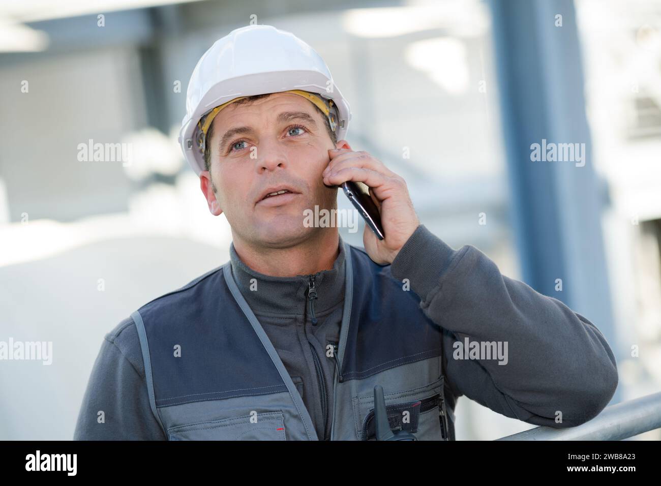 engineer man construction worker happy talking using a smartphone Stock Photo