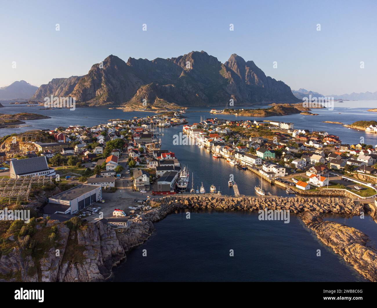 The small fishing town of Henningsvaer, Lofoten, Norway at sunset, from a drone point of view. Clear blue sky and crisp colors. Stock Photo