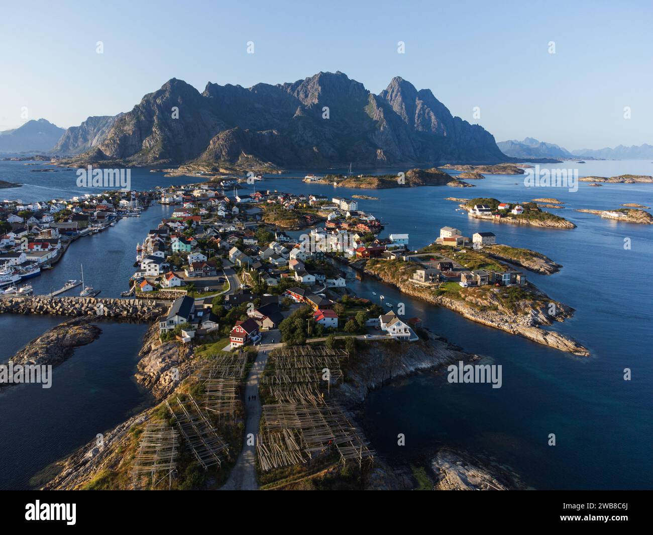 The small fishing town of Henningsvaer, Lofoten, Norway at sunset, from a drone point of view. Clear blue sky and crisp colors. Stock Photo