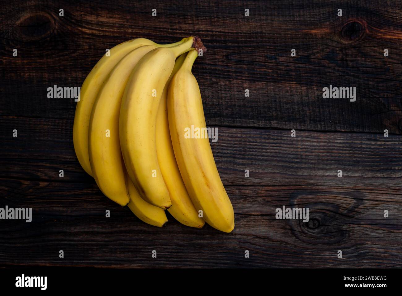 Some bananas on a white wooden table. Empty copy space for editor's text. Stock Photo