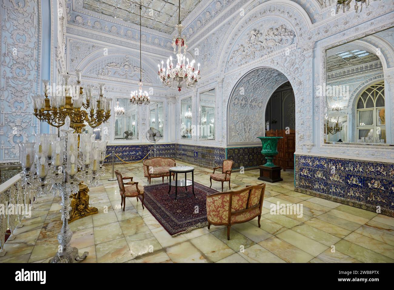 Interior view of a small sitting hall in the Golestan Palace with crystal chandeliers and intricate plaster work on walls. Tehran, Iran. Stock Photo