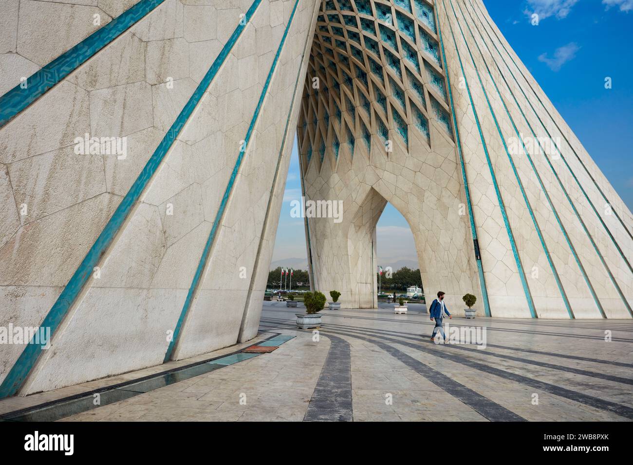 Man walks at the Azadi Tower (Freedom Tower), an iconic landmark in Tehran, Iran. Stock Photo