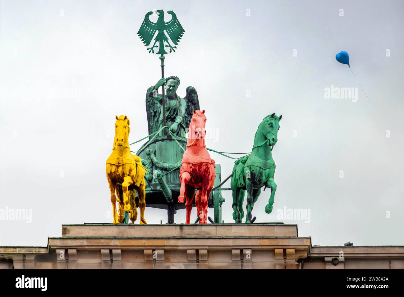 Bundeskanzler Scholz als Lenker der Quadriga auf dem Brandenburger Tor, Symbol Ampelkoalition, Berlin, Januar 2024 Deutschland, Berlin, Januar 2024, Bundeskanzler Olaf Scholz als Lenker der Ampelkoalition, Quadriga auf dem Brandenburger Tor mit symbolisch nur drei Pferden und Bundesadler, gelb, rot, grün, Symbolfoto Ampelkoalition aus SPD, Grünen und FDP, blauer Luftballon am Himmel als Symbol für die AfD, Rechtsruck in der deutschen Politik, böses Omen für weiter steigende Umfragewerte der Rechten, Politik, Himmel über Berlin, *** Federal Chancellor Scholz driving the Quadriga on the Brandenb Stock Photo