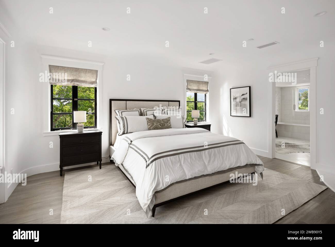 A modern bedroom with white walls, grey accents and flooring Stock ...