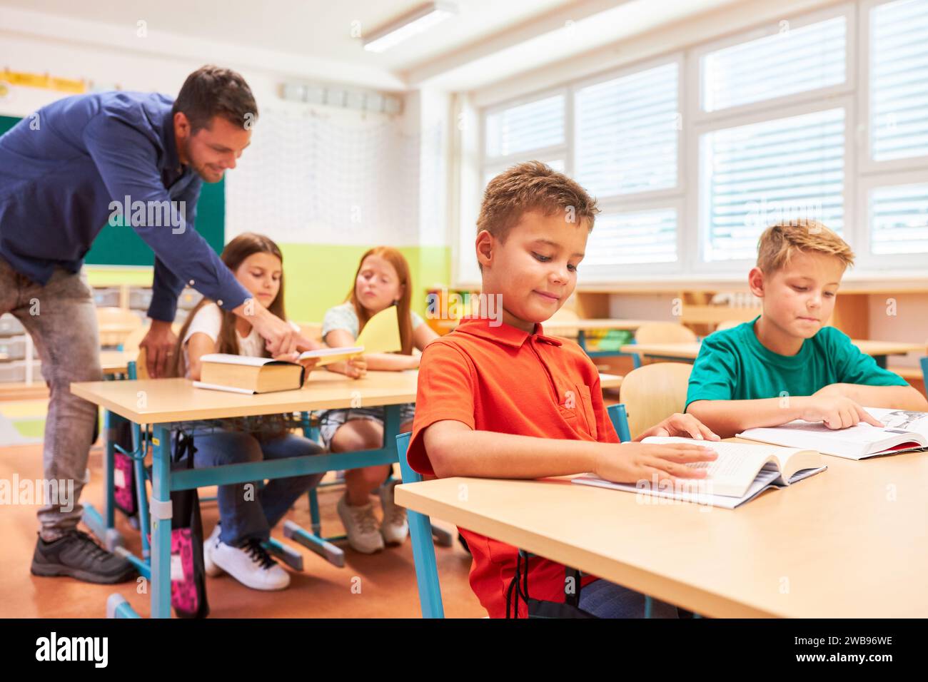 Group of elementary school children studying together in classroom Stock Photo