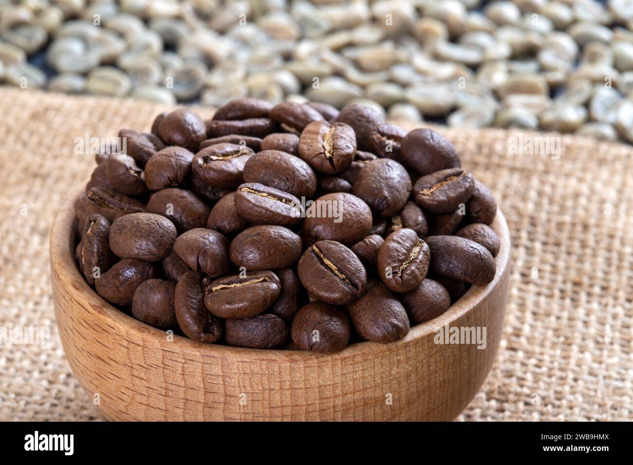 Green coffee with roasted coffee beans on burlap sack,top view Stock Photo
