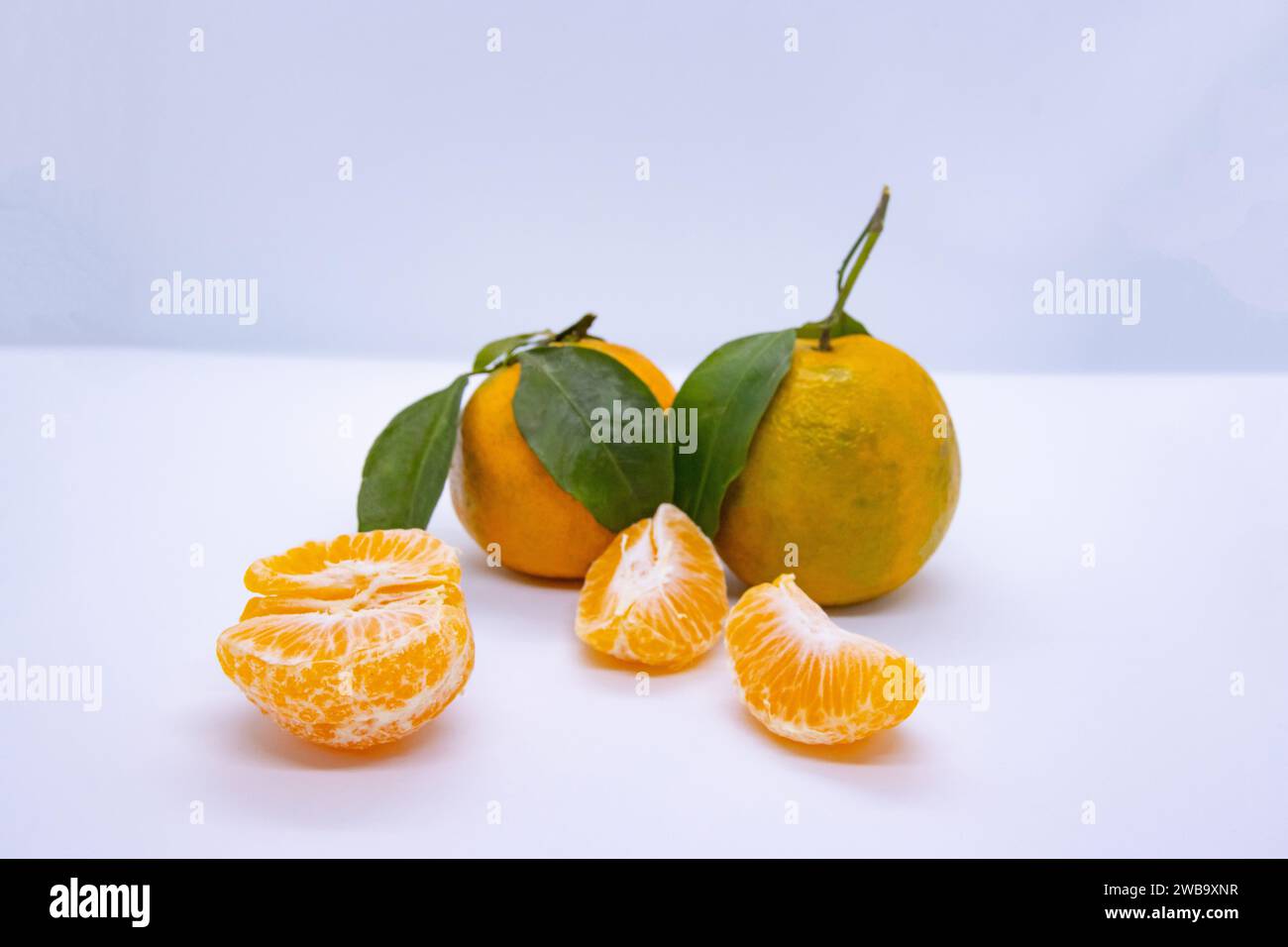 Orange Tangerine Green Citrus Fruit with leaves in isolated white background Stock Photo