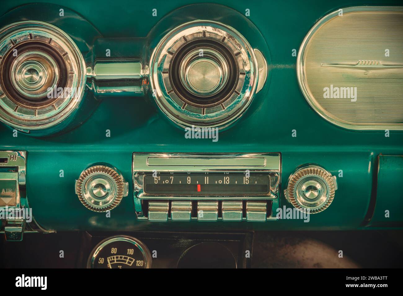 Retro styled image of an old car radio inside a green classic American car Stock Photo
