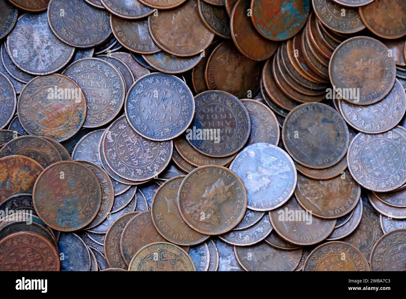 Indian Old vintage coins, vintage coin abstract with English & Indian coins in forefront. Stock Photo