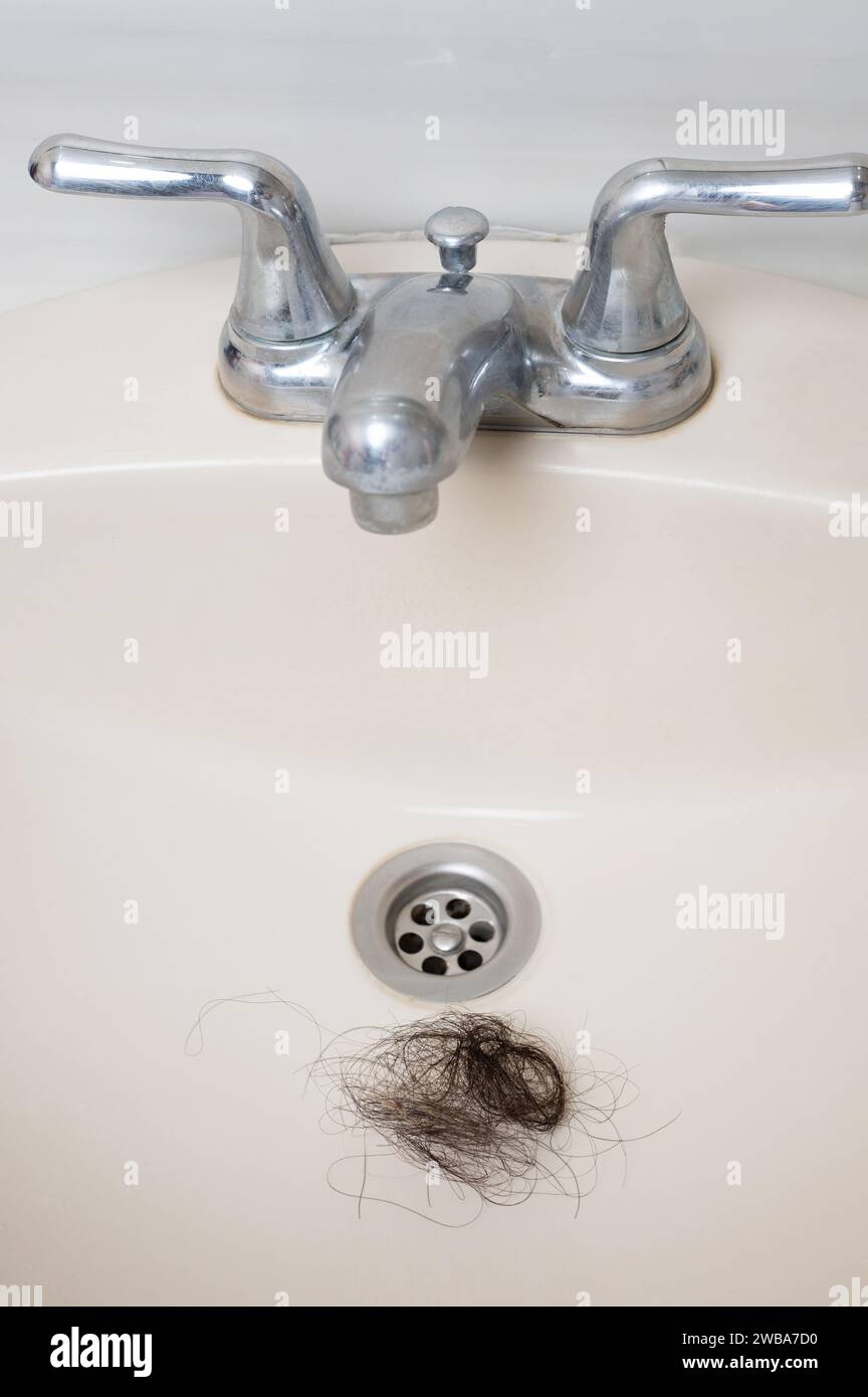 Messy clog hair in ceramic sink macro clsoe up view Stock Photo