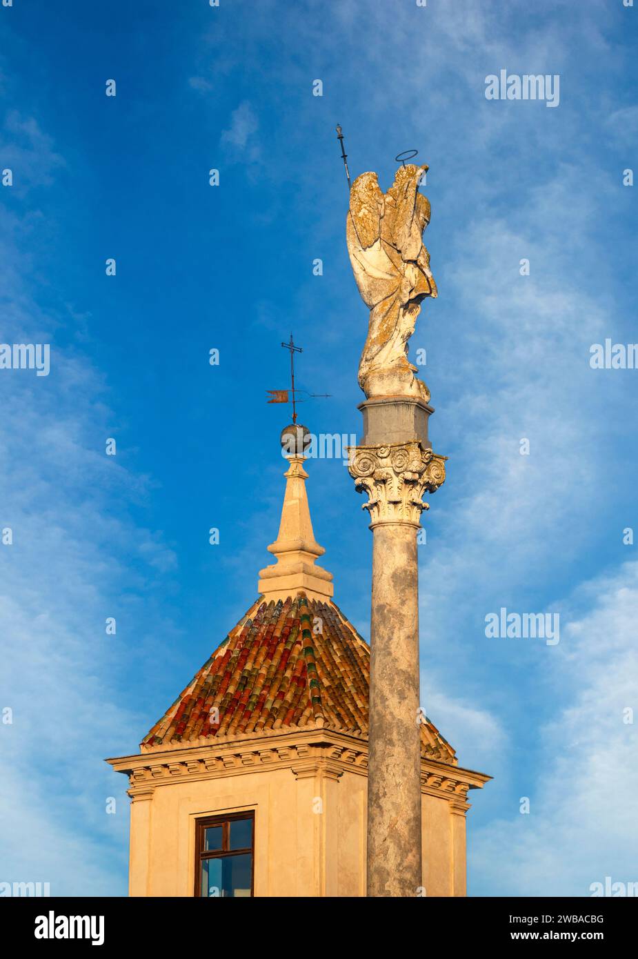Sculpture of the Triumph of San Rafael de la Puerta del Puente with the tower of the bishopric of Córdoba, Andalusia, Spain, in the background Stock Photo