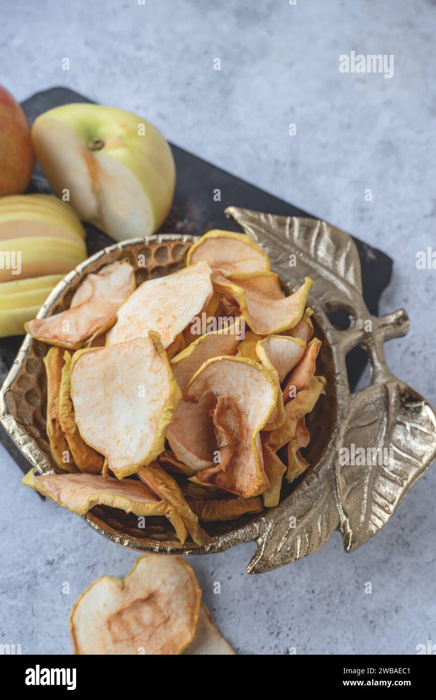 Dried apple chips in a bowl. Dehydrated apples. Homemade dried organic apple slices. Top view, flat lay, close-up. Stock Photo
