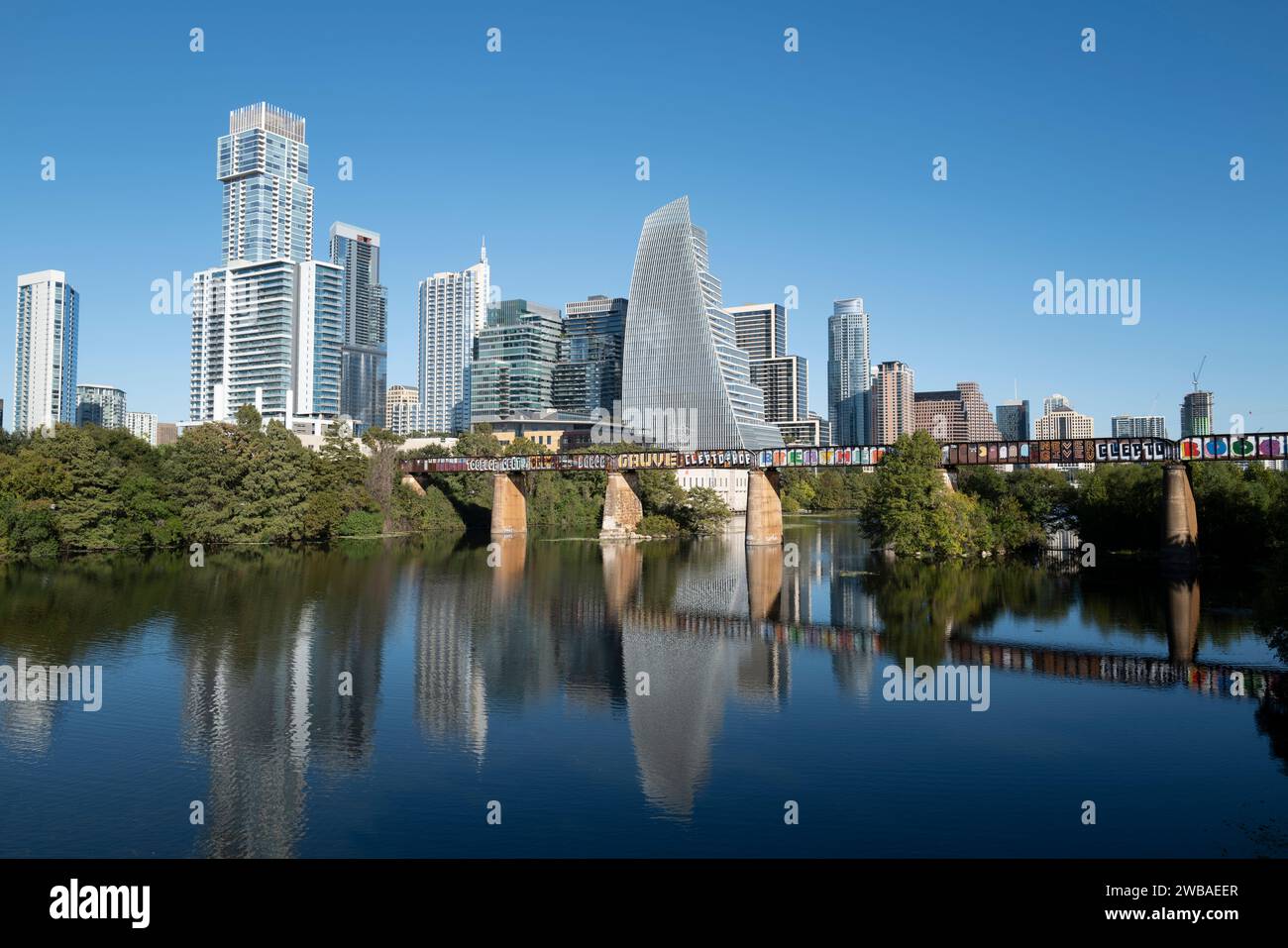 Austin Texas downtown skyline with Railroad Bridge crossing Ladybird Lake aka Colorado River and Town Lake. Stock Photo