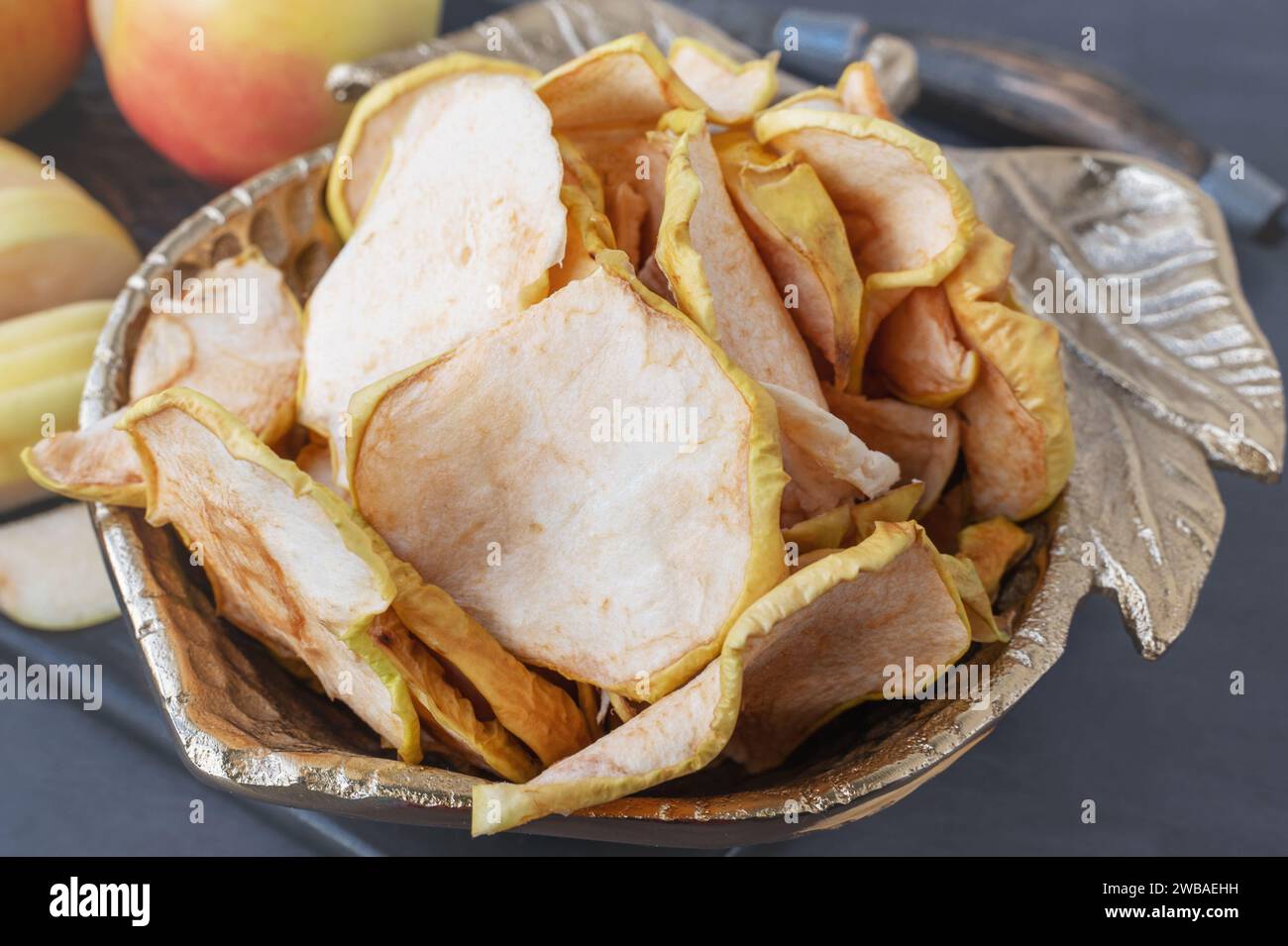 Dried apple chips in a bowl. Dehydrated apples. Homemade dried organic apple slices. Stock Photo