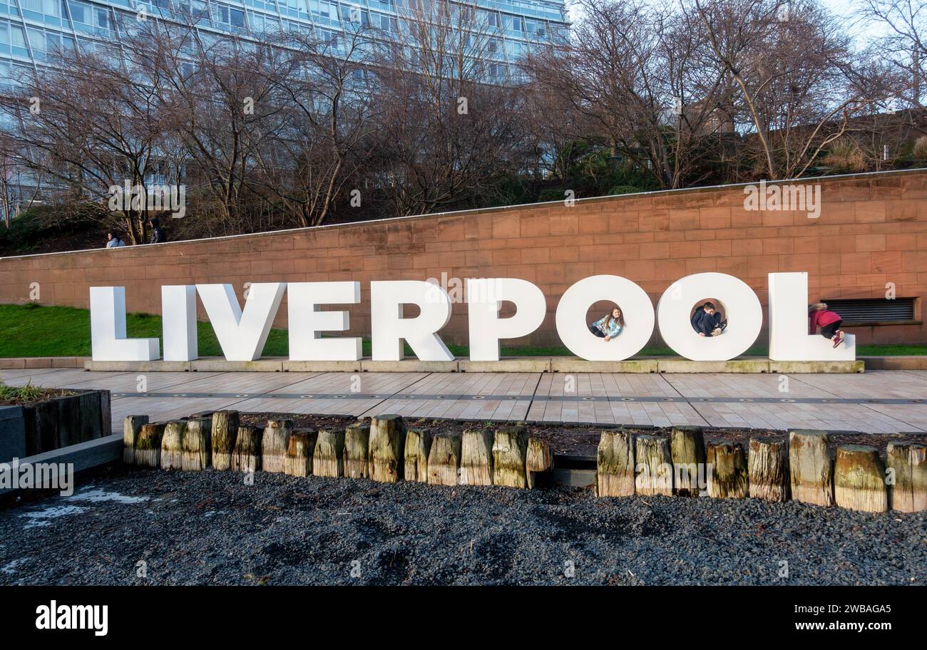 Three children playing in the letters of the Liverpool sign Stock Photo