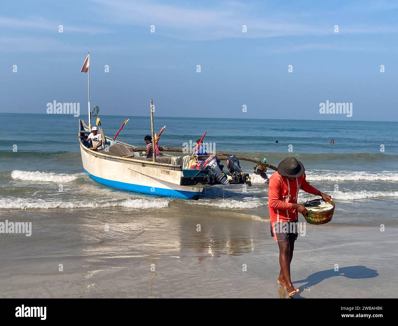 Fishermen on the beach at Benaulim in Goa, India, pull their nets ashore and sort their catch Stock Photo