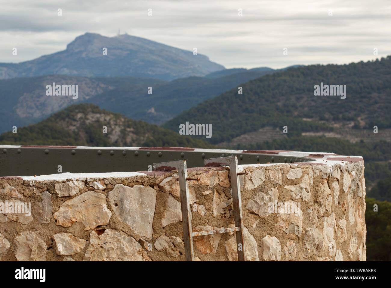 San Antonio of Alcoi fire water tank with layers of mountains in the background and the top of the Sierra Aitana, Spain Stock Photo