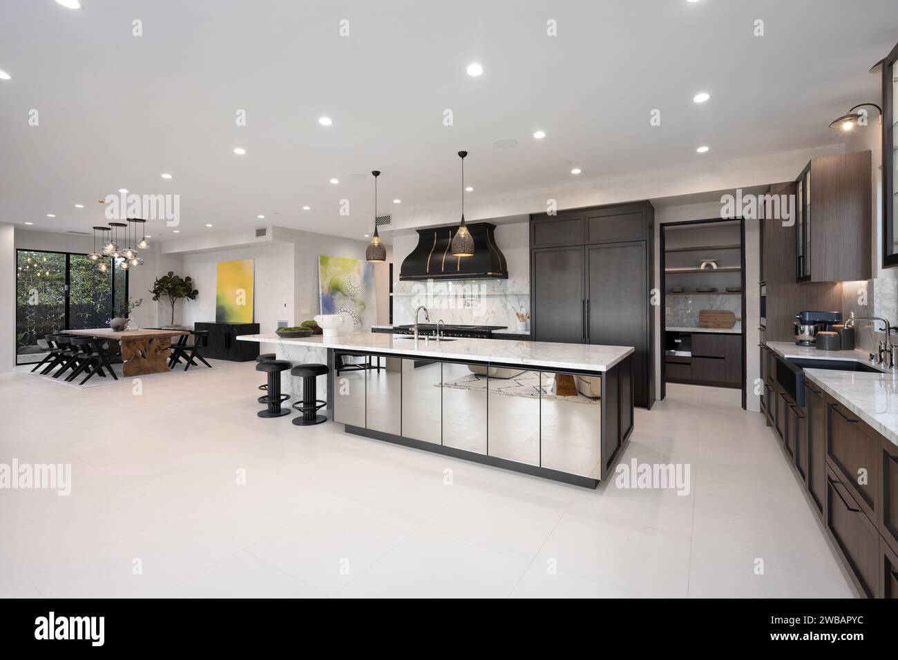 This bright and airy kitchen is illuminated by multiple overhead lights, creating a warm and inviting atmosphere Stock Photo