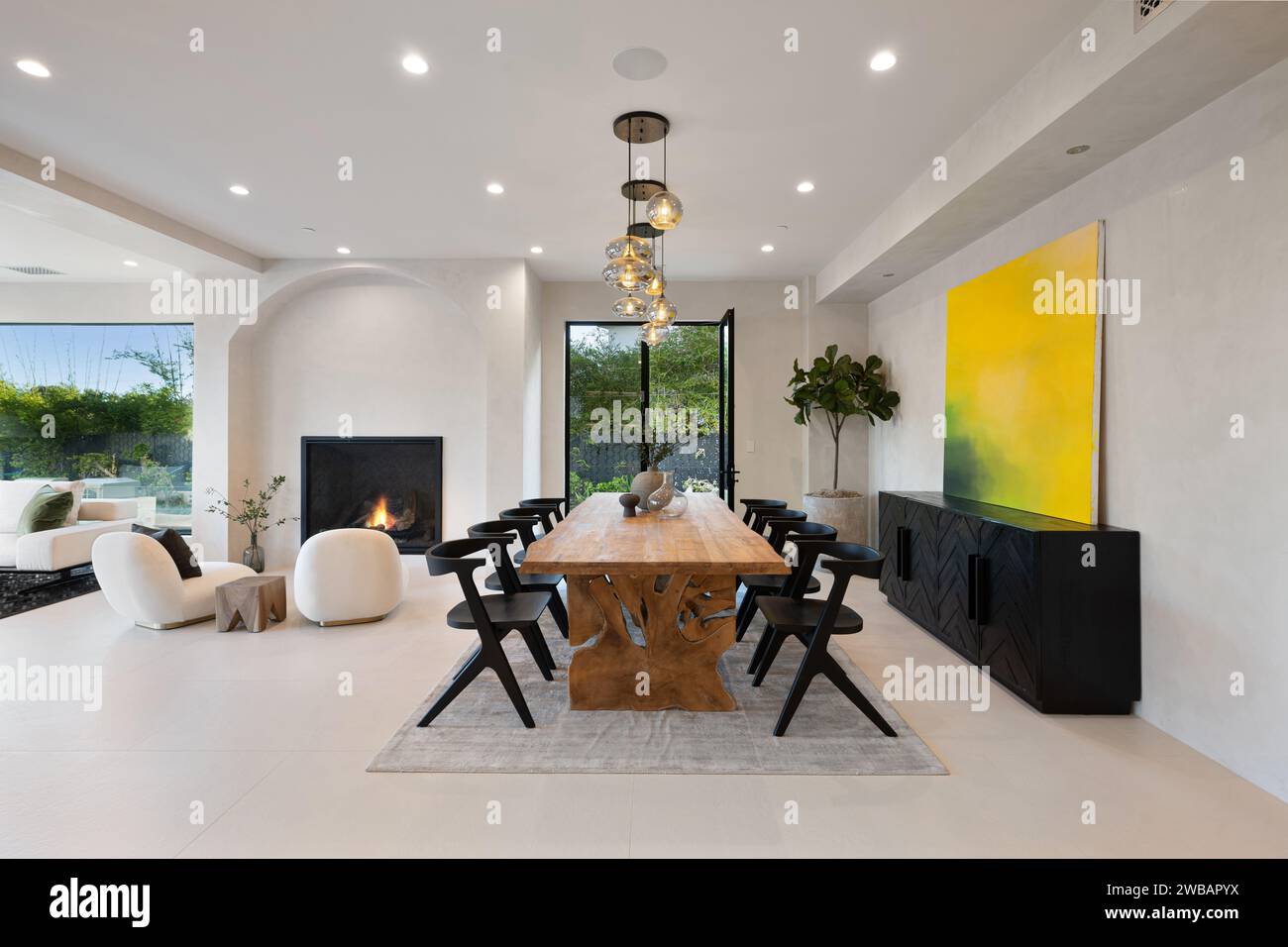 A spacious dining room with a long wooden table and six chairs surrounding it, perfect for hosting a family dinner or a gathering with friends Stock Photo