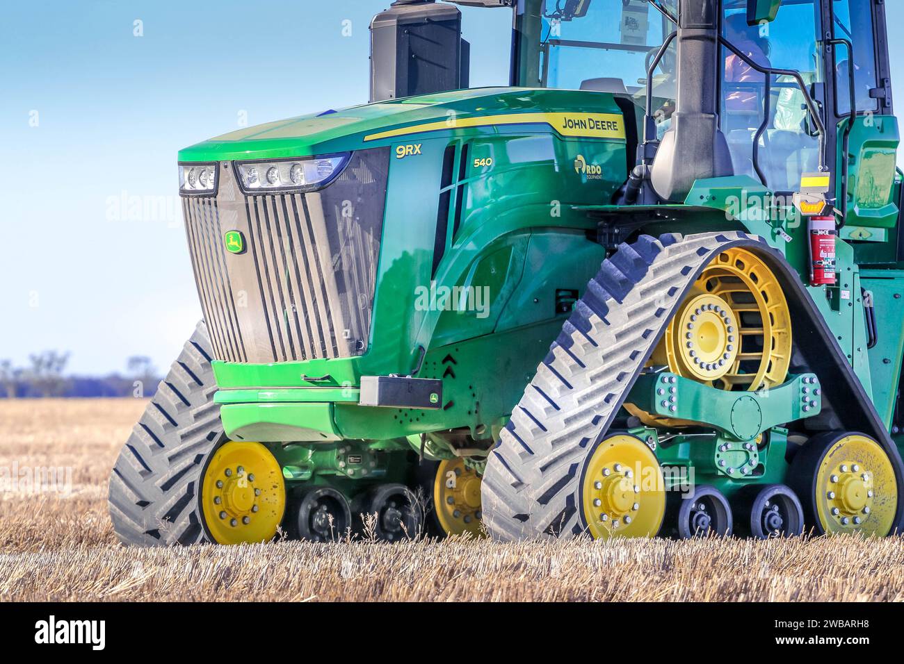 A tractor is ascending an incline of land, preparing the area for