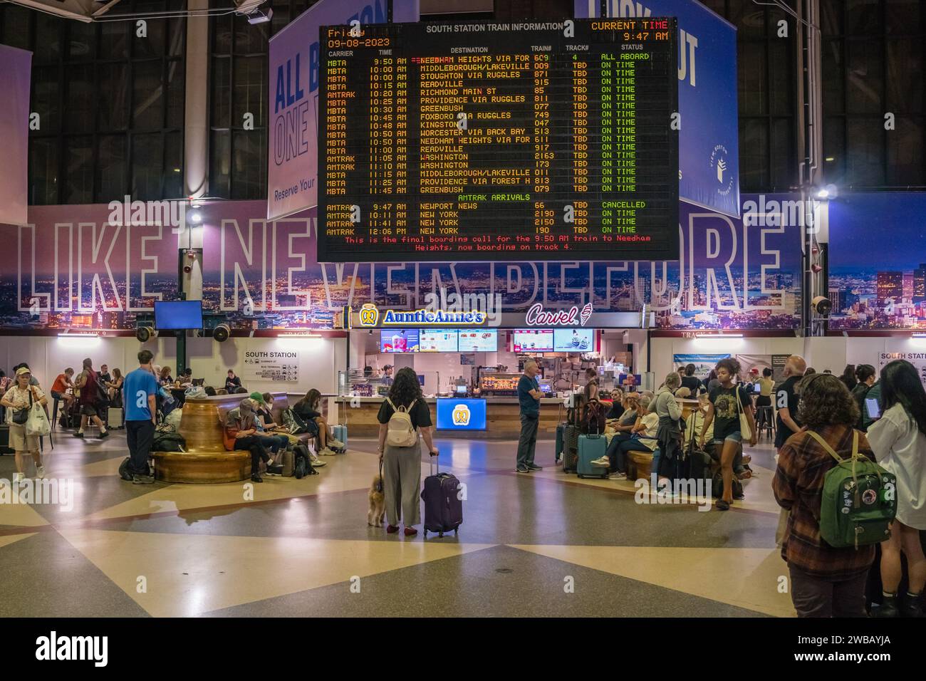 Boston, MA, US-September 8, 2023: Passengers reading sign at South Station, a busy train station. Stock Photo