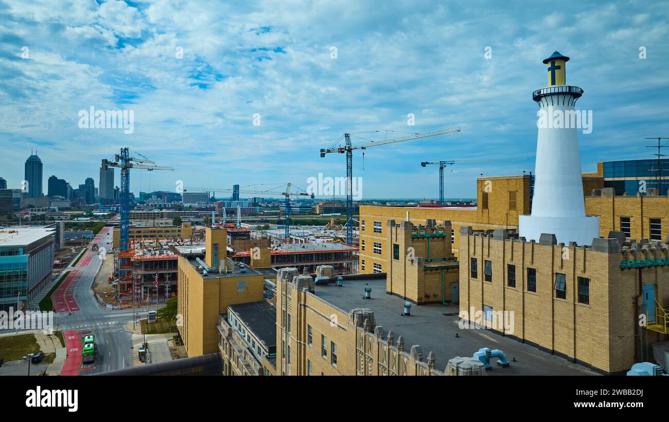 Aerial Urban Expansion in Indianapolis with Cranes and Lighthouse Tower ...