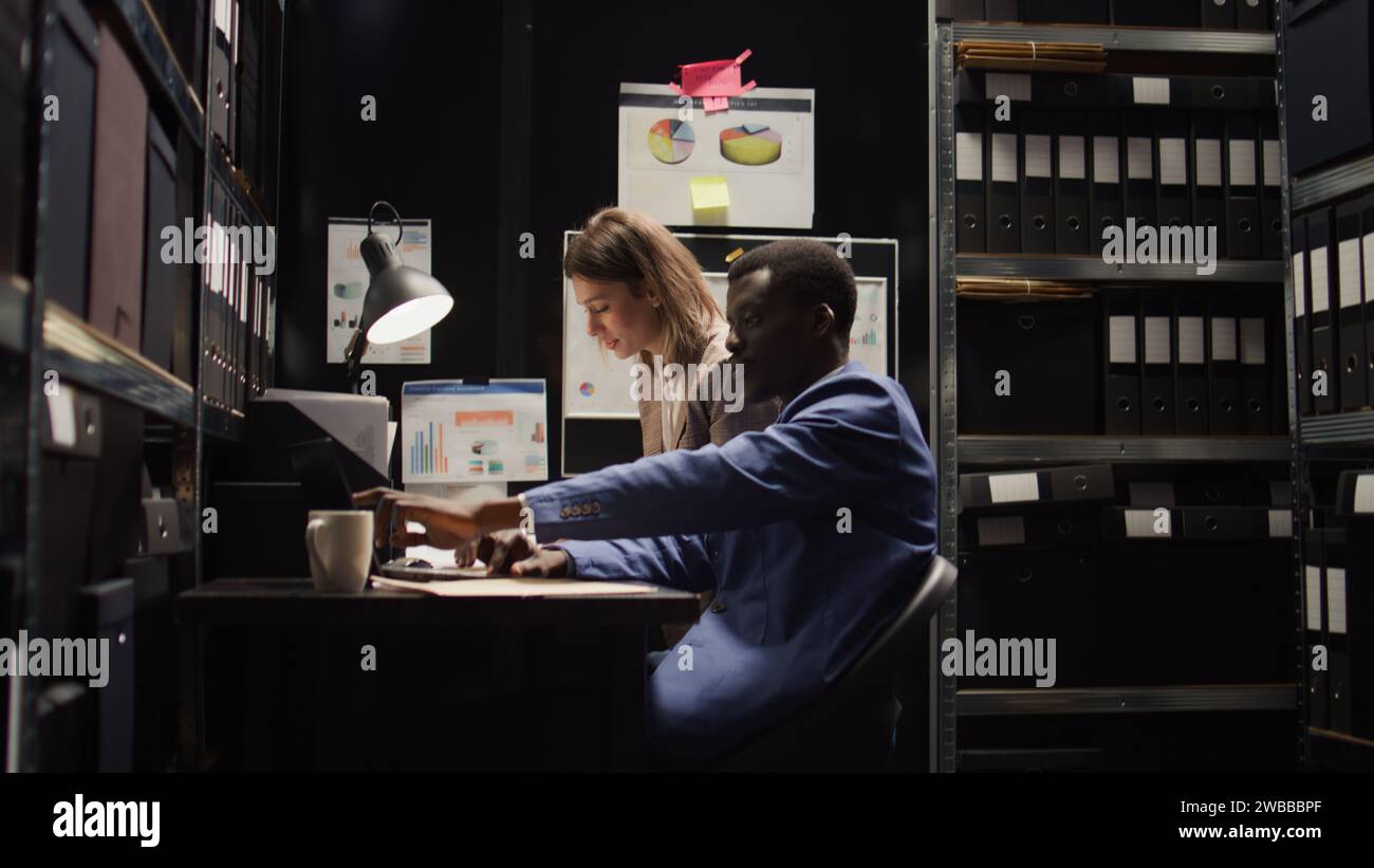 Diverse investigators studying the evidence in neatly organised office ...