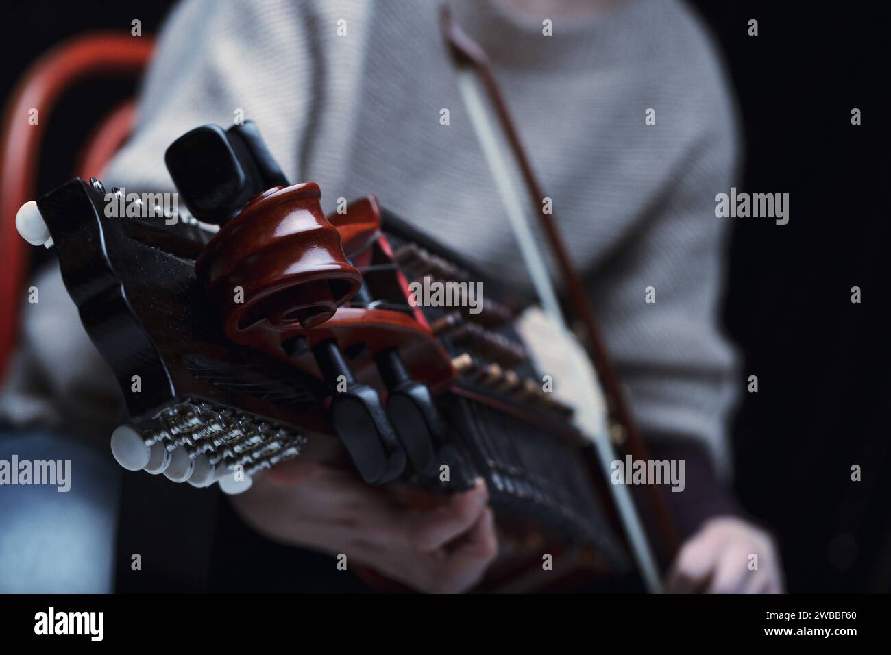 The fingers of a Nyckelharpa player dance on the keys, bringing ancient