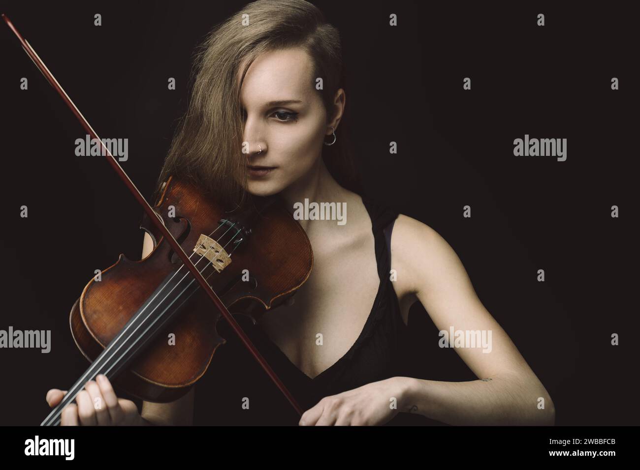 artist and her violin share a silent dialogue, a moment captured where