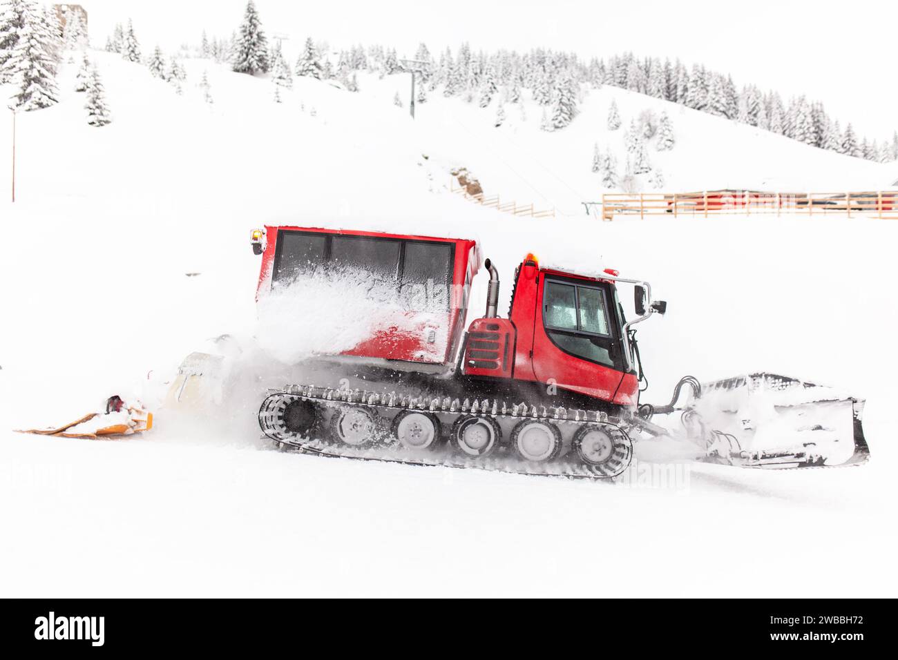 Red snowcat vehicle preparing ski slopes. Stock Photo