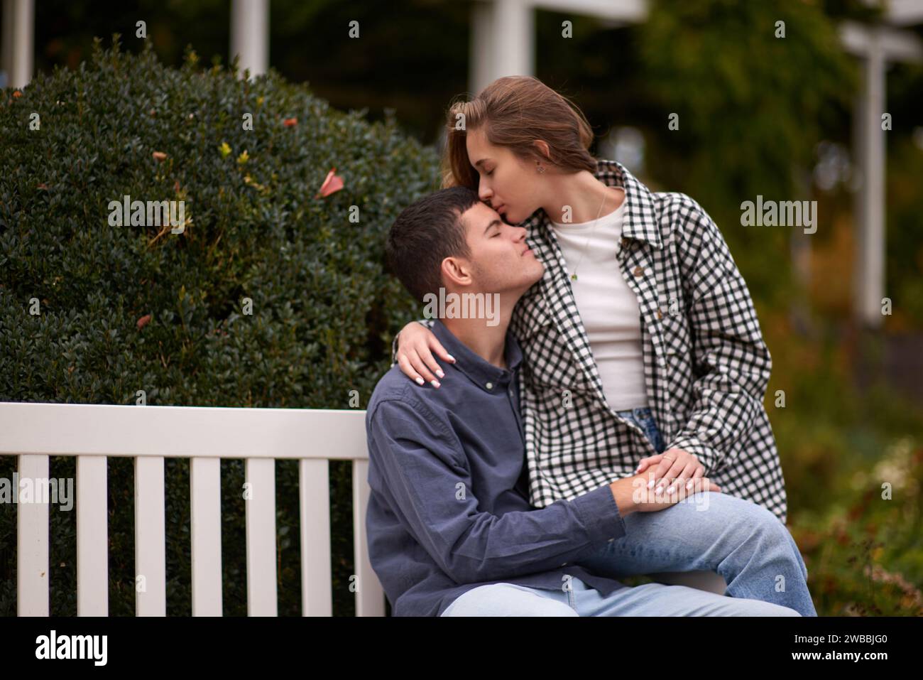 Romantic couple kiss on bench in city park hi-res stock photography and ...