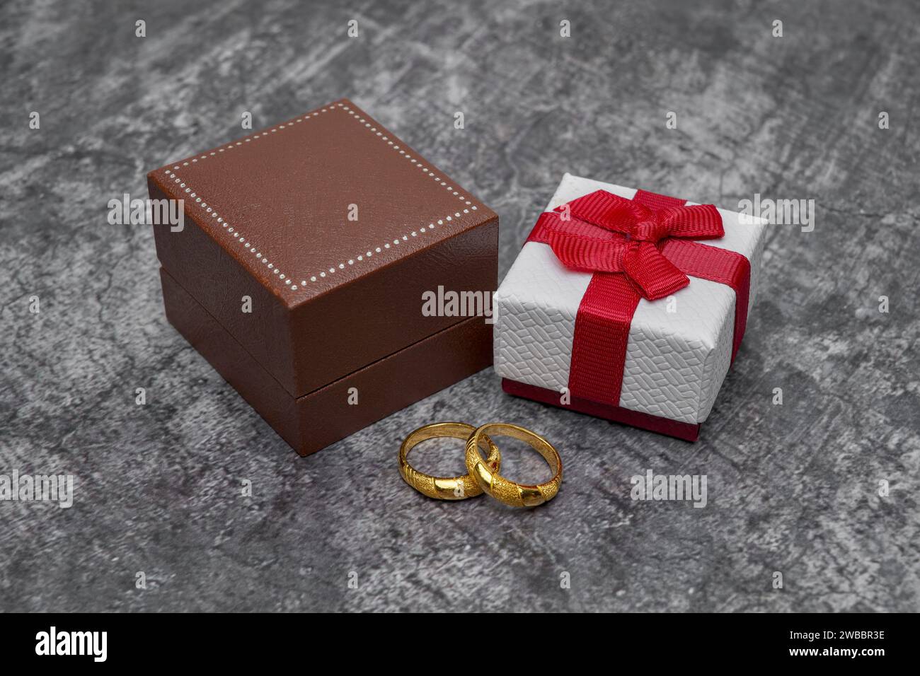 Brown case, small gift box, and two gold rings Stock Photo