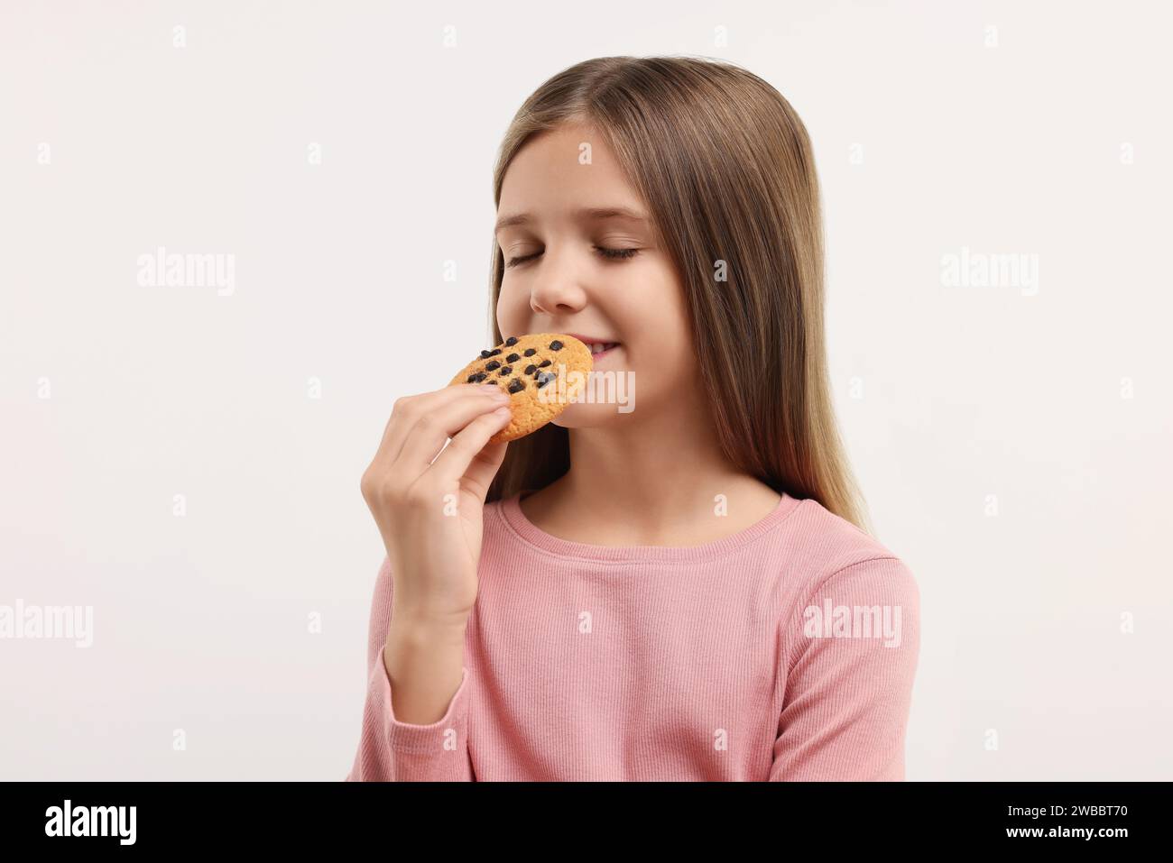 Cute girl with chocolate chip cookie on white background Stock Photo ...