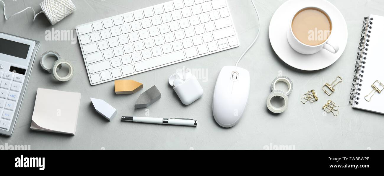 Flat lay composition with wired computer mouse and stationery on light grey table. Space for text Stock Photo