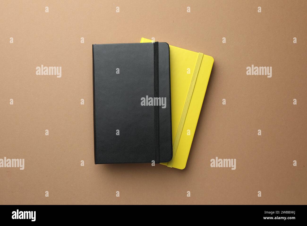 Different notebooks on light brown background, top view Stock Photo