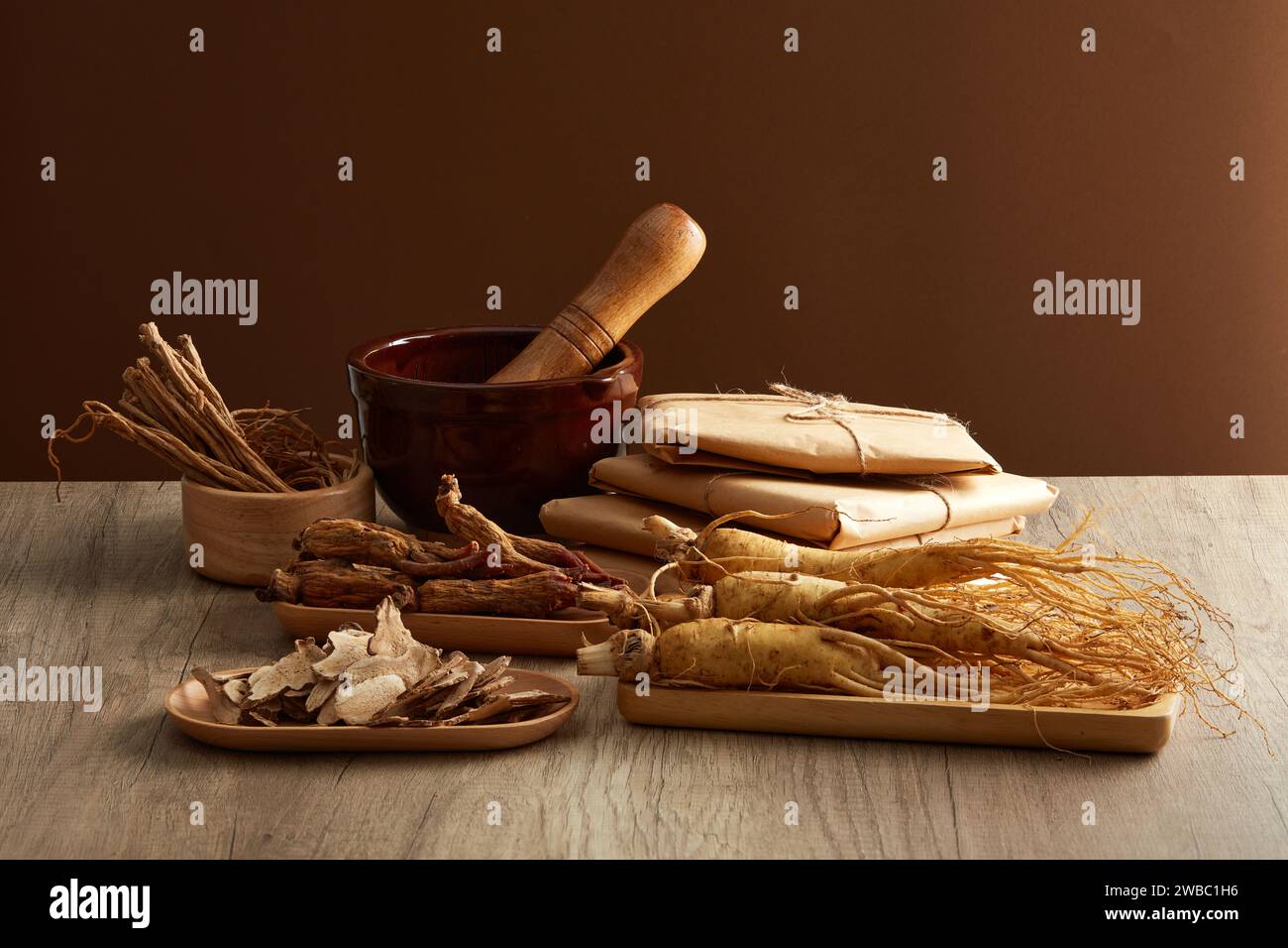 Front view of ginseng roots on tray, rhizoma rhe and codonopsis pilosula displayed on wooden table. Healthy herbs. Advertisement scenes for traditiona Stock Photo