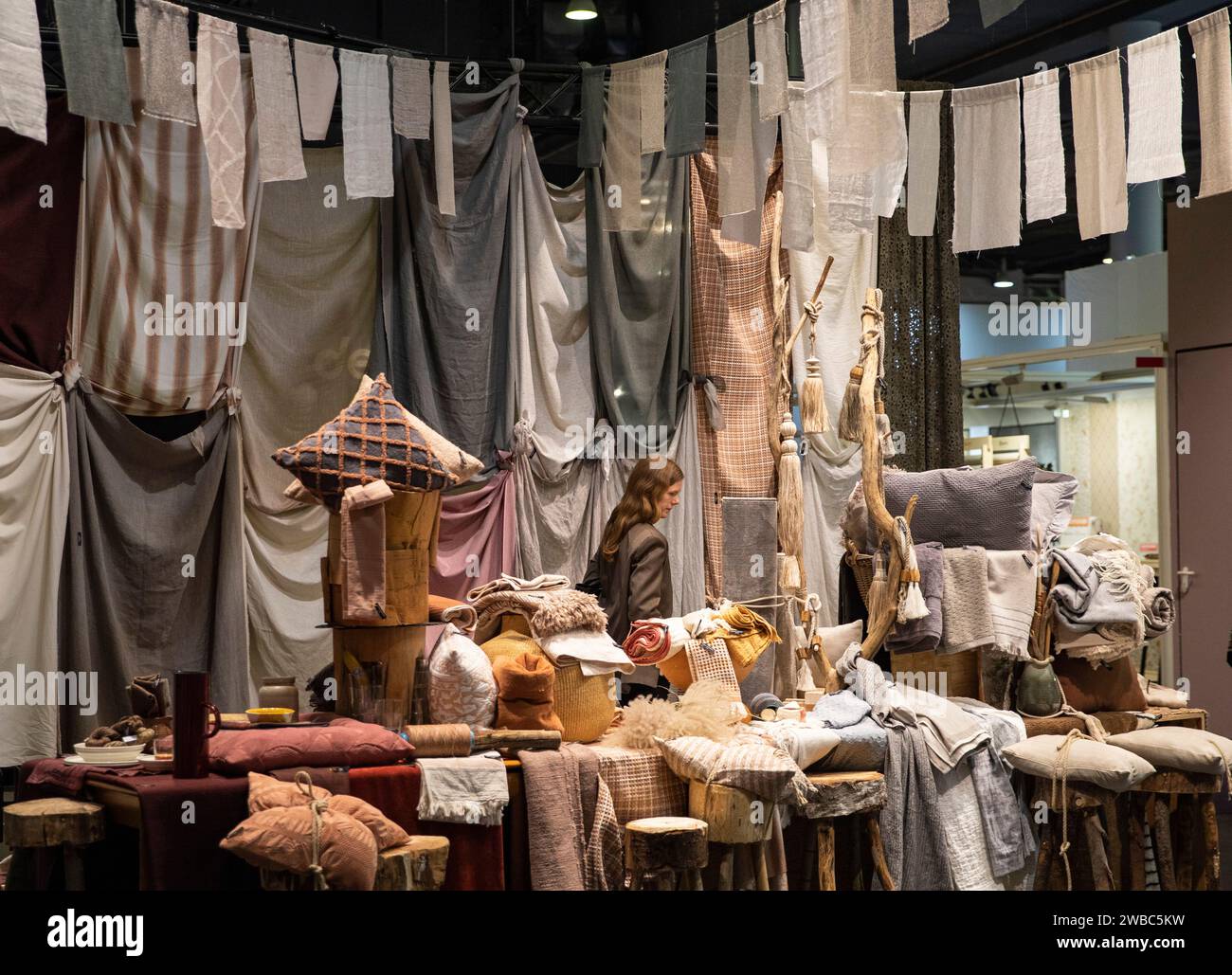 (240110) FRANKFURT, Jan. 10, 2024 (Xinhua) A visitor walks past textile samples at the