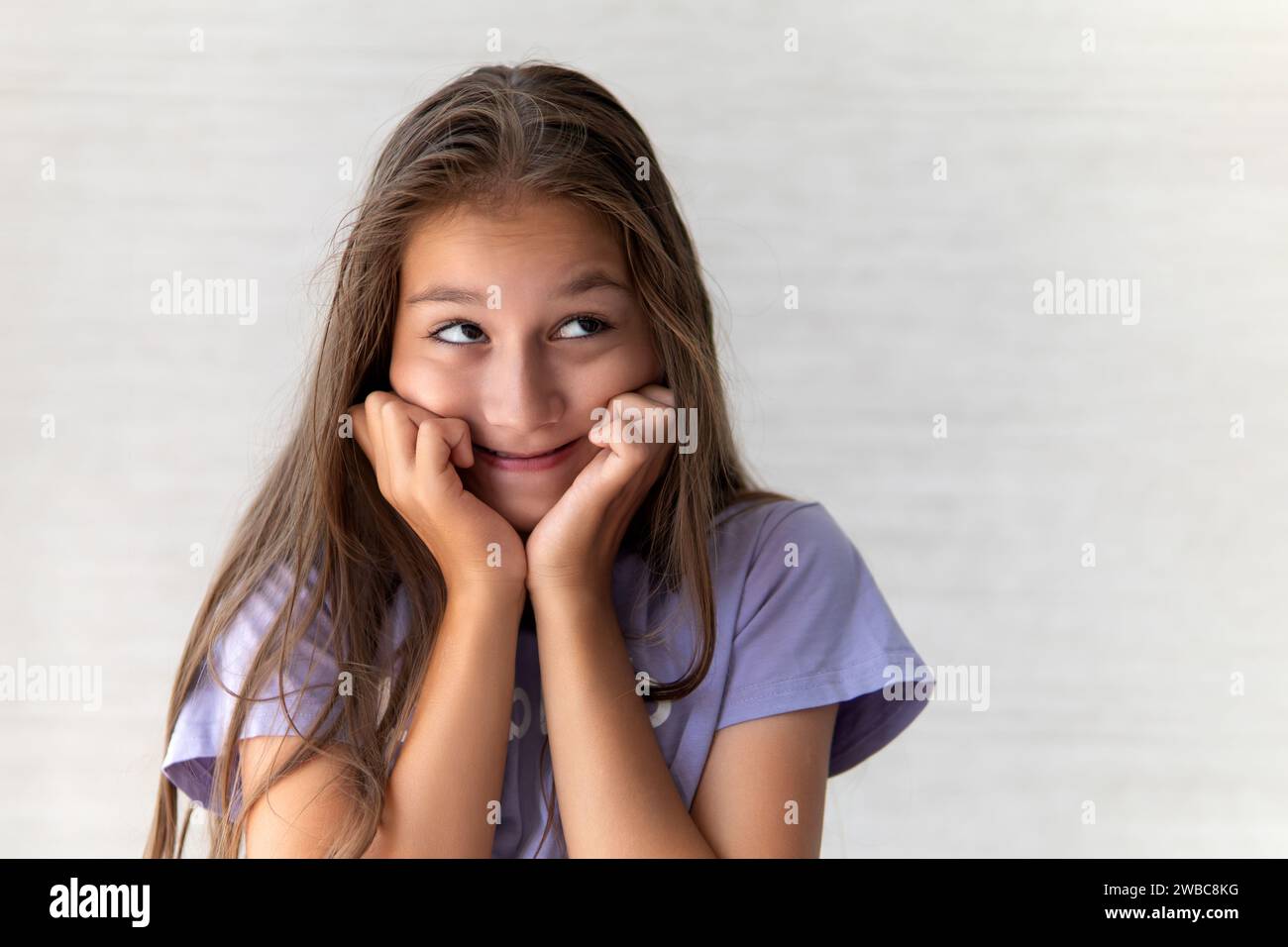 Surprised shocked child toddler girl with hands on her cheeks on light ...