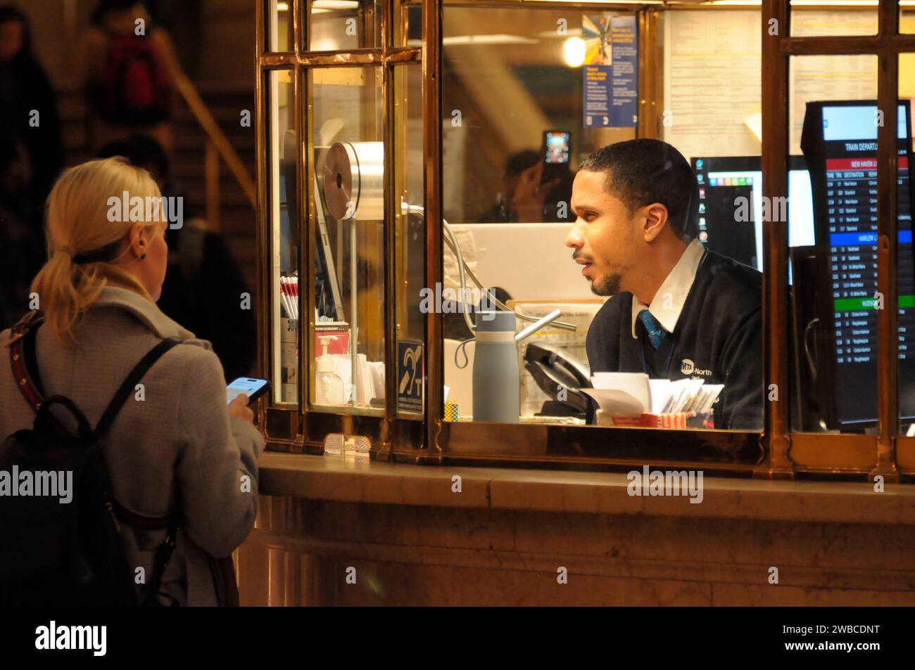 New York, United States. 09th Jan, 2024. A person inside an information booth, right, talks to a