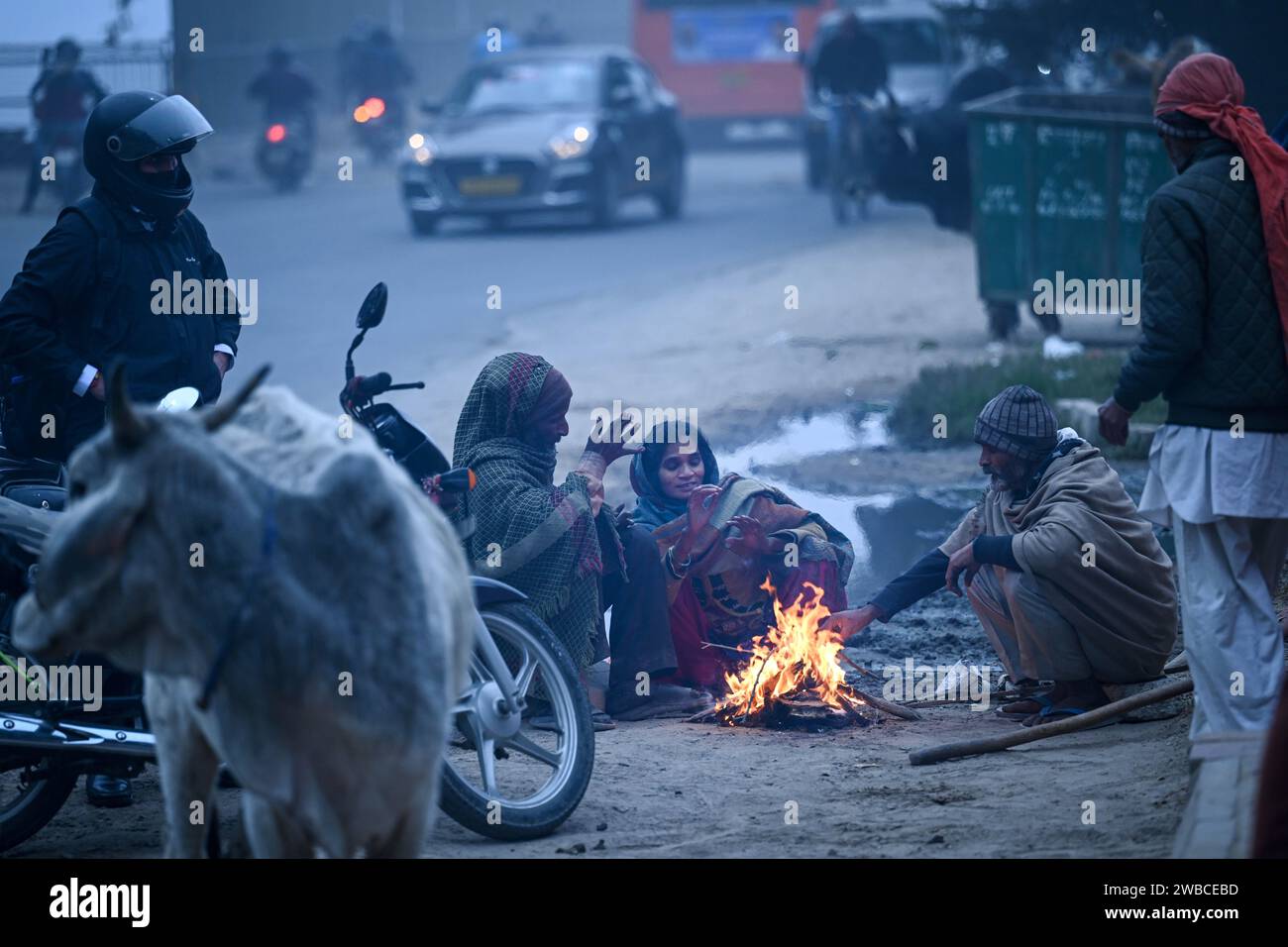 New Delhi, India. 09th Jan, 2024. NEW DELHI, INDIA - JANUARY 9: People seen siting around a bonfire at Wazirabad on January 9, 2024 in New Delhi, India. Delhi and its adjoining areas woke up to a cold and foggy morning on Tuesday and the minimum temperature dropped to 6 degrees Celsius in the national capital. (Photo by Sanchit Khanna/Hindustan Times/Sipa USA) Credit: Sipa USA/Alamy Live News Stock Photo