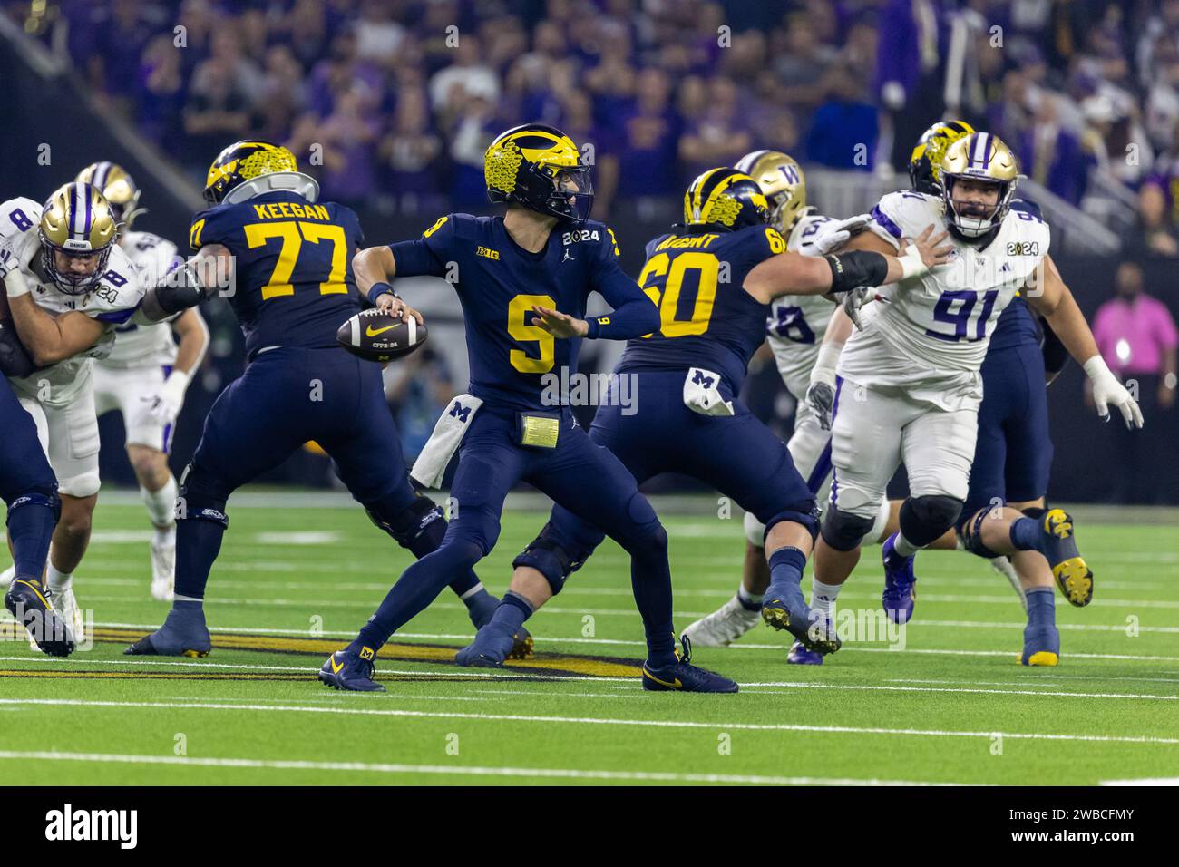 Michigan Wolverines quarterback J.J. McCarthy (9) passes behind the blocking of his offensive line against the Washington Huskies during the 2024 Coll Stock Photo