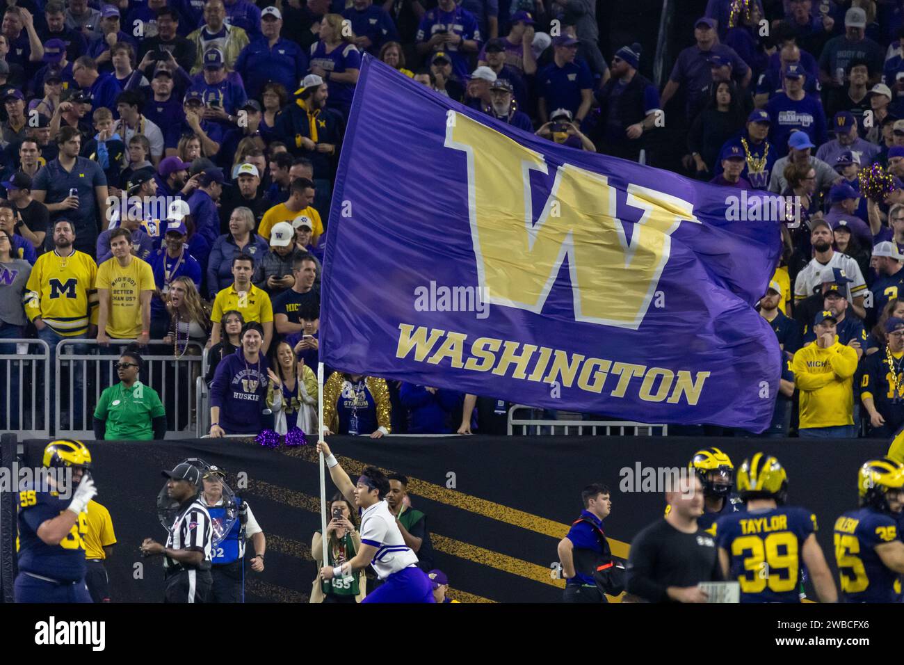 Washington Huskies cheerleader carries the flag after a touchdown against the Michigan Wolverines during the 2024 College Football Playoff National Ch Stock Photo